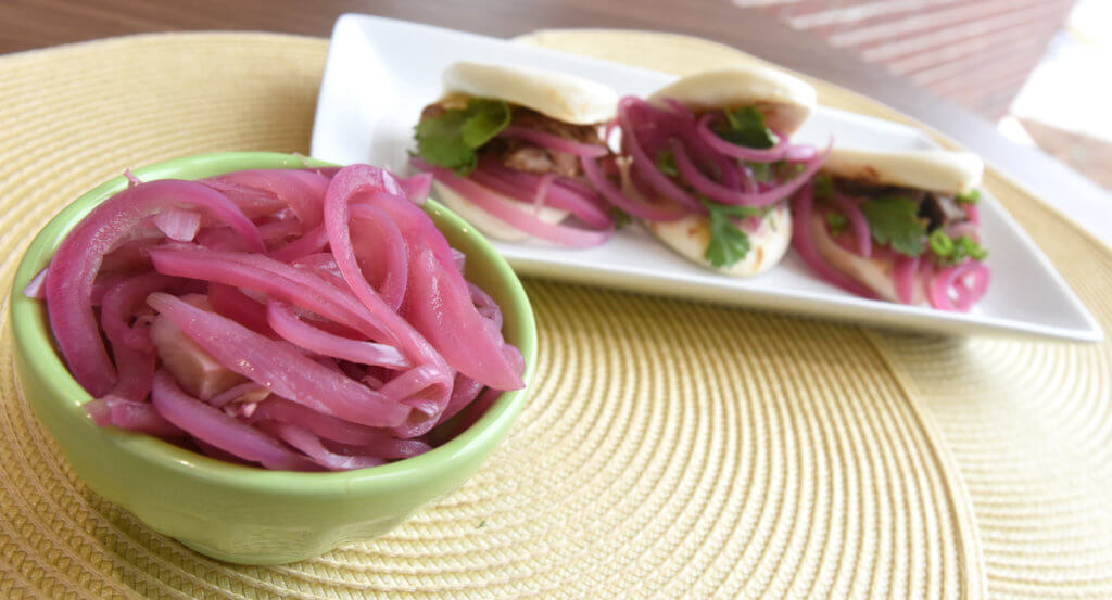 Pickled Onions in a bowl and Hoisin Beef Bao Bun Sandwich