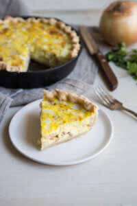 A slice of Quiche Lorraine on a white plate