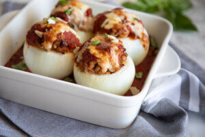 Stuffed Onions with Marinara in white baking dish