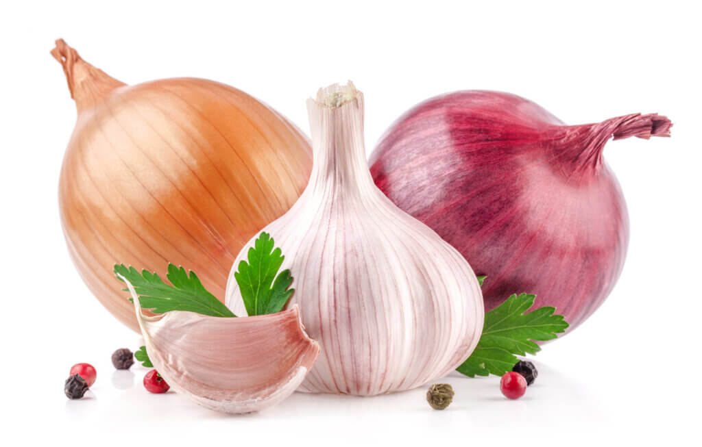 Red onion, yellow onion and clove of garlic on white background