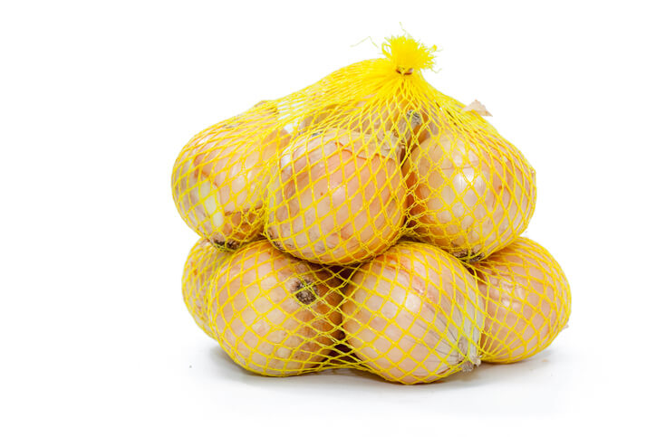 Bag of onions on white background